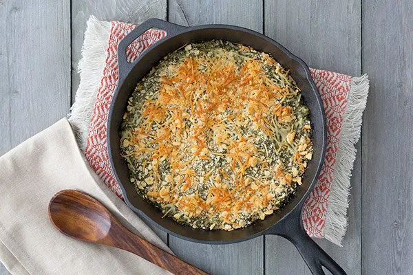 Baked Spinach Gratin in an Iron Pan on a Wood Table with Linens