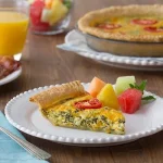 Cheesy Spinach & Tomato Quiche on a white plate