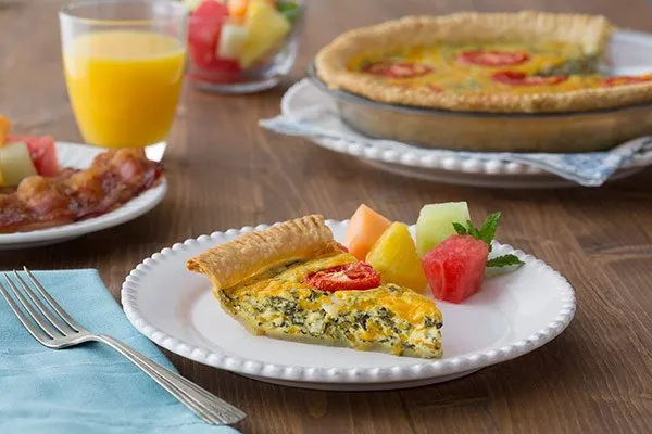 Cheesy Spinach & Tomato Quiche on a white plate